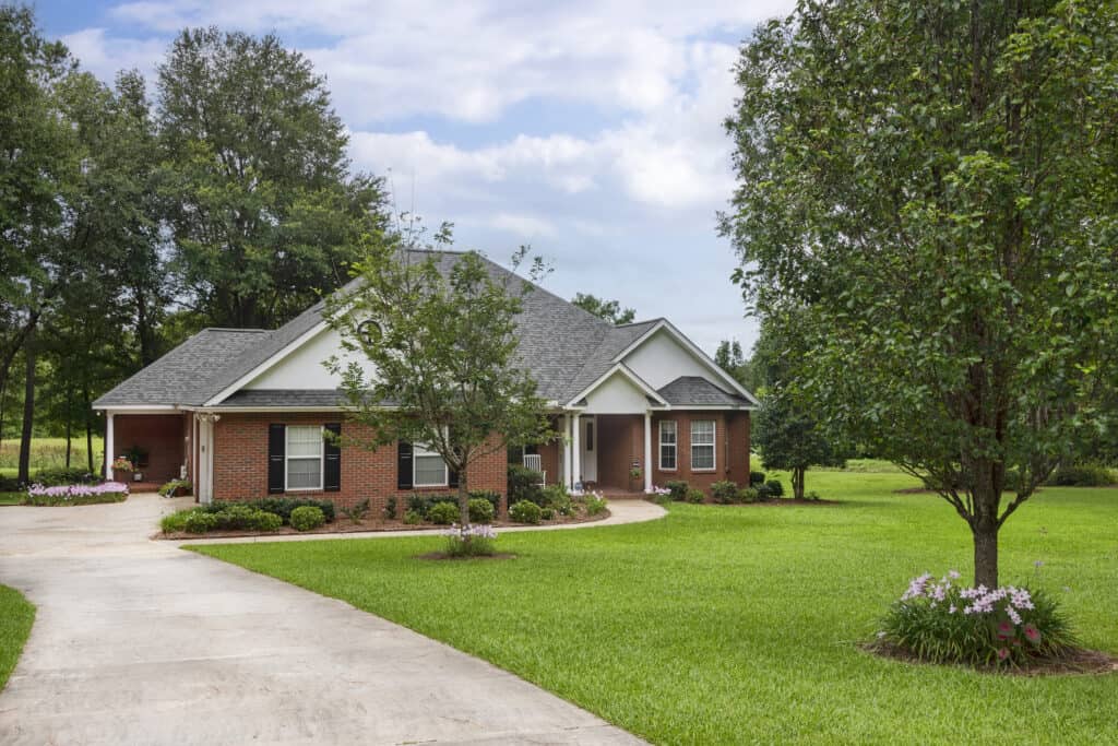 Beautiful suburban house with lush green lawn and mature trees in Middleburg, FL.