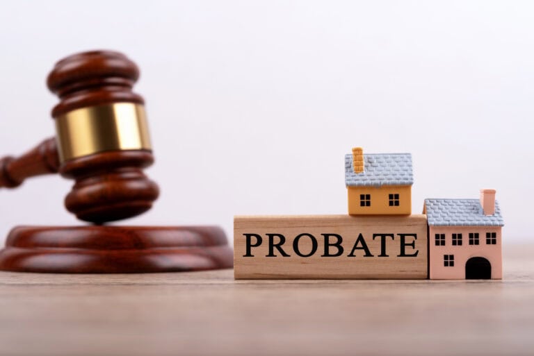 Gavel and miniature houses representing probate process and property sale.