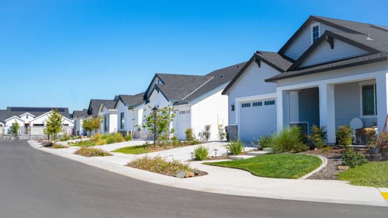 Beautiful suburban neighborhood with modern white houses and well-maintained lawns.