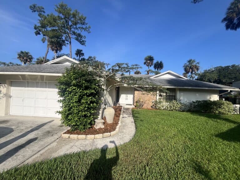 Single-story home with lush front yard and palm trees in Ponte Vedra Beach, FL.